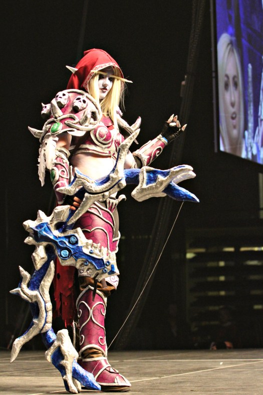 A cosplayer costumed as a night-elf hunter poses as Jessica Nigri looks on agog.